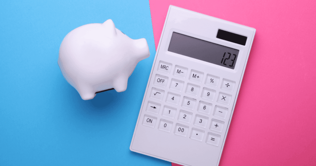 Hucha con forma de cerdo y calculadora sobre fondo bicolor, representando el ahorro y la gestión de gastos deducibles para autónomos.