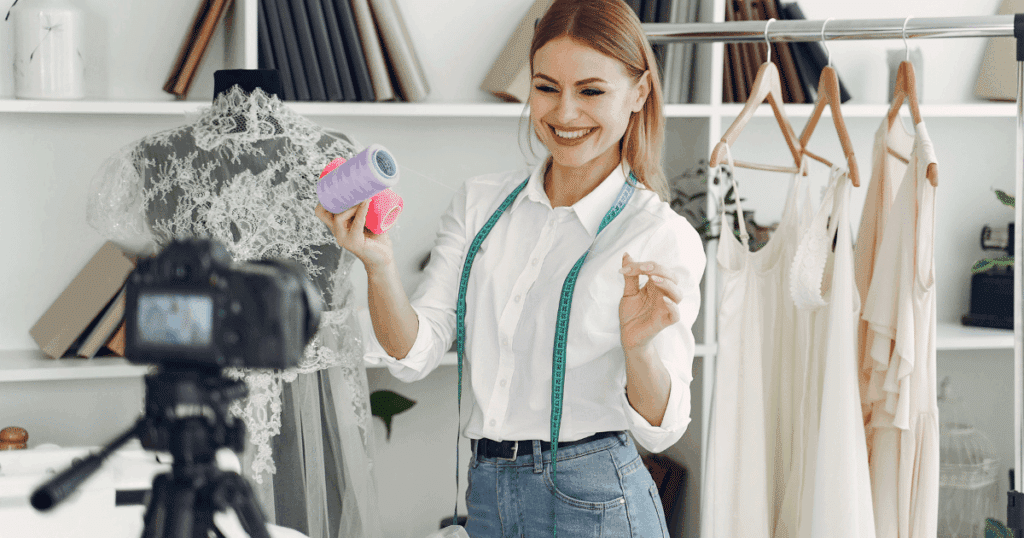 Una emprendedora sonriente en su taller de moda usando la ayuda de capitalizar el paro para autónomos.