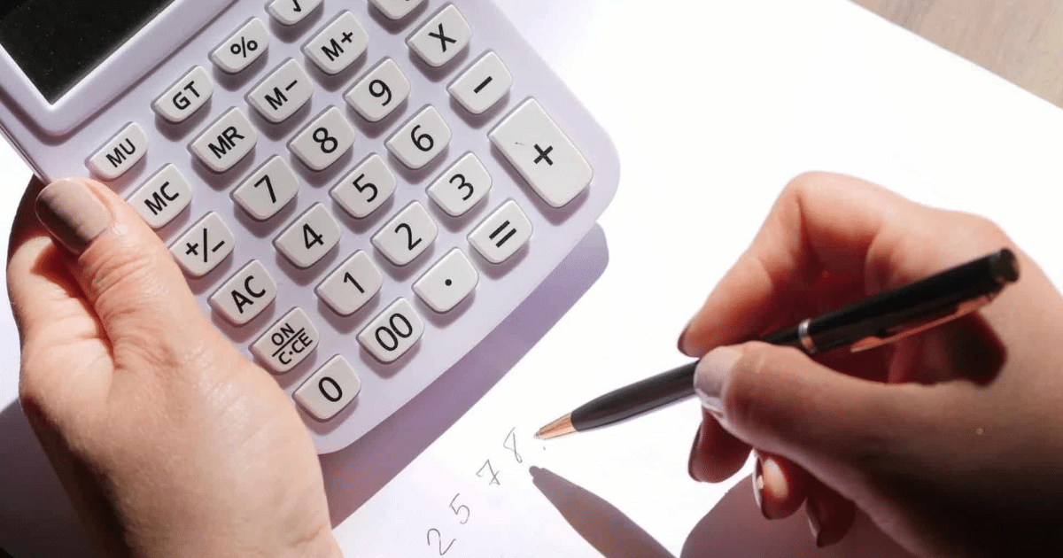 Manos de un autónomo haciendo cuentas con una calculadora y un bolígrafo para saber cuánto es lo máximo que te puede devolver Hacienda en la declaración de la Renta.