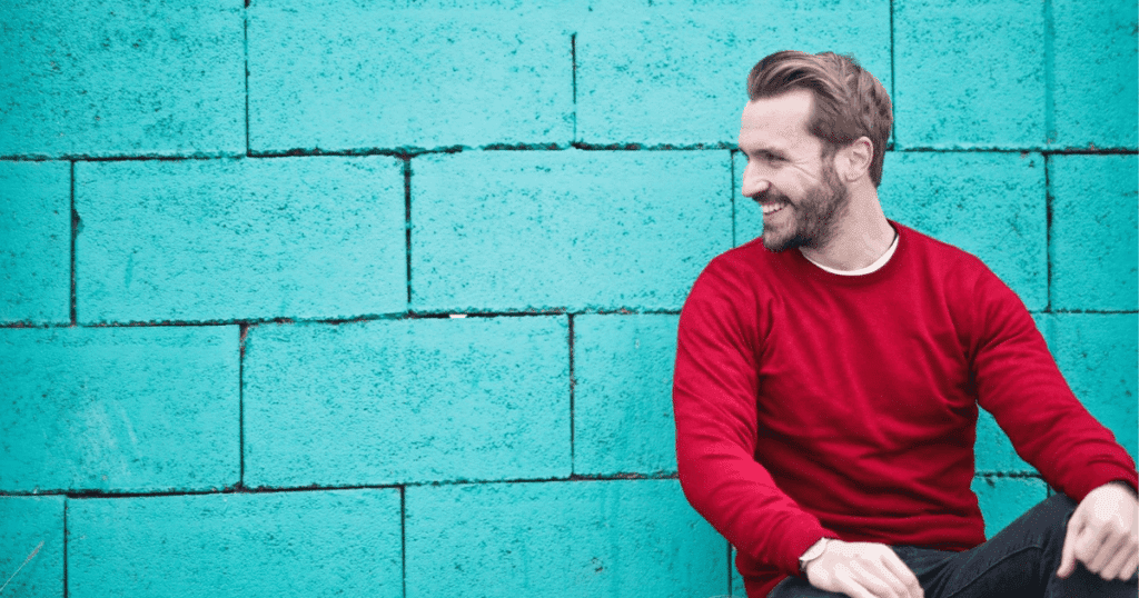 Hombre joven sonriente y relajado, representando la tranquilidad de contratar planes de pensiones de empleo para autónomos y asegurar su futuro financiero.