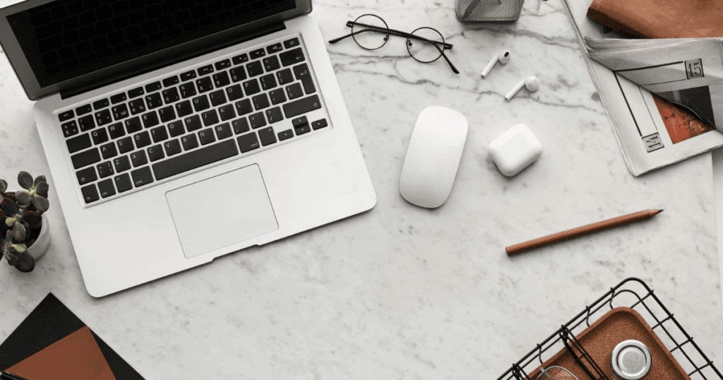 Escritorio profesional con ordenador portátil, gafas y agenda, ilustrando la realidad sobre el ordenador gratis del kit digital para autónomos y pymes.
