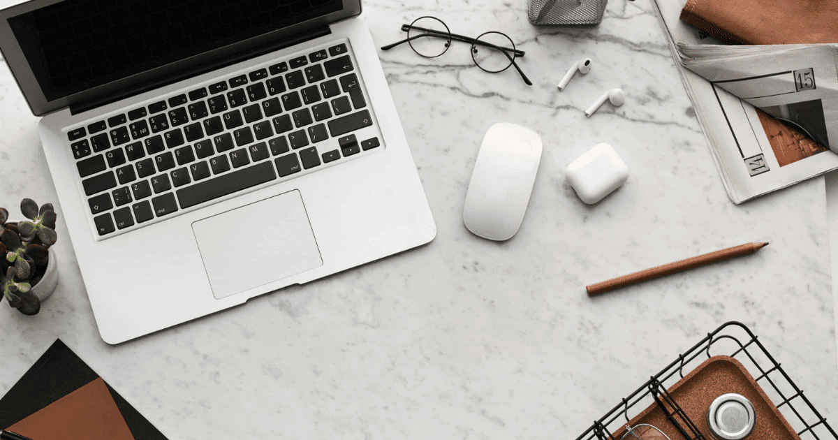 Escritorio profesional con ordenador portátil, gafas y agenda, ilustrando la realidad sobre el ordenador gratis del kit digital para autónomos y pymes.