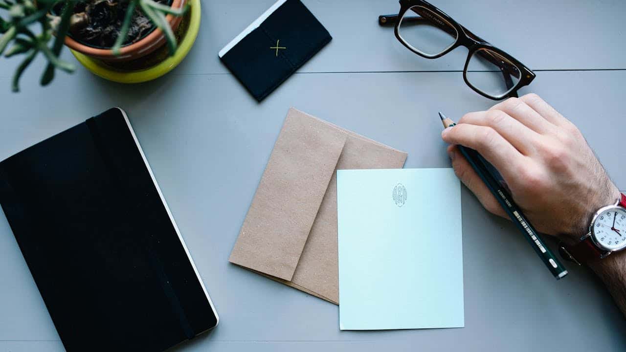 Autónomo revisando documentación para presentar alegaciones ante una propuesta de liquidación de la AEAT sobre un escritorio con cuaderno, sobre de Hacienda y gafas de lectura.