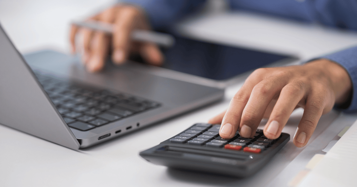 Un autónomo usando una calculadora y un portátil para organizar el calendario fiscal de abril 2026.