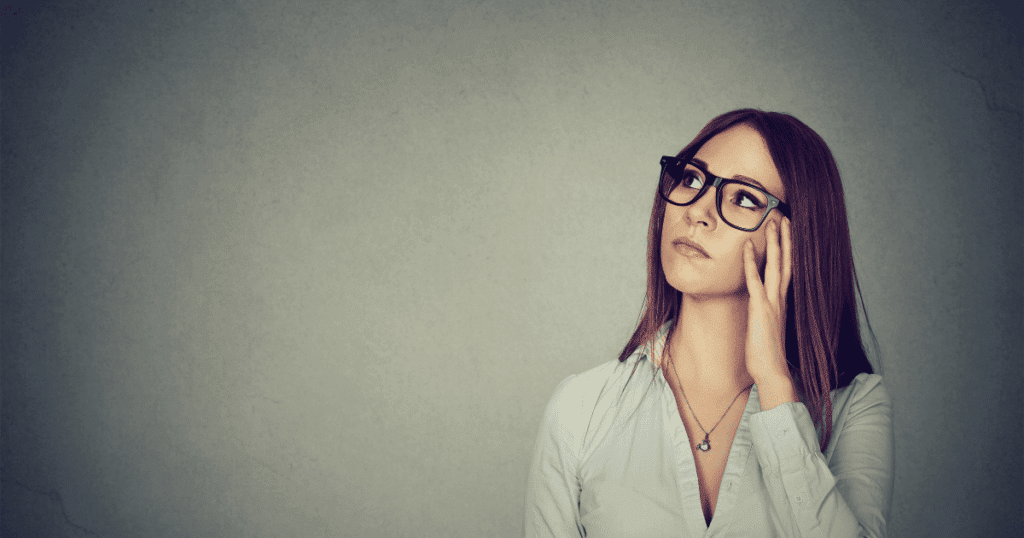 Una mujer autónoma pensando con expresión reflexiva, junto a un espacio para una infografía del IVA de 2026 (General 21%, Reducido 10%, Superreducido 4%). Imagen para la guía de tipos de IVA para autónomos.