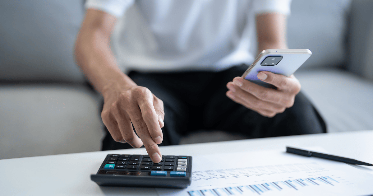 Persona revisando datos financieros y calculando impuestos para emitir una factura proforma profesional.