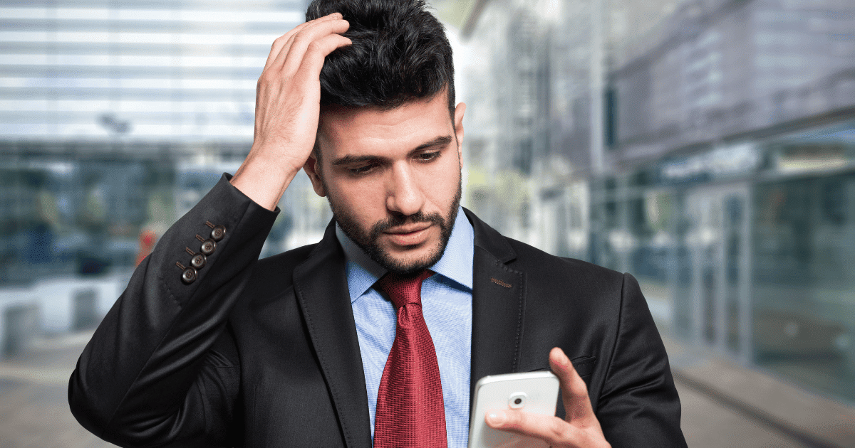 Un autónomo preocupado consulta su teléfono móvil tras recibir una alerta de la seguridad social notificación regularización 2024 en su buzón electrónico.