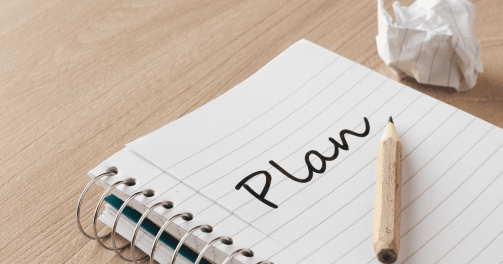 Cuaderno de notas con la palabra Plan escrita a lápiz para organizar la gestión de un negocio