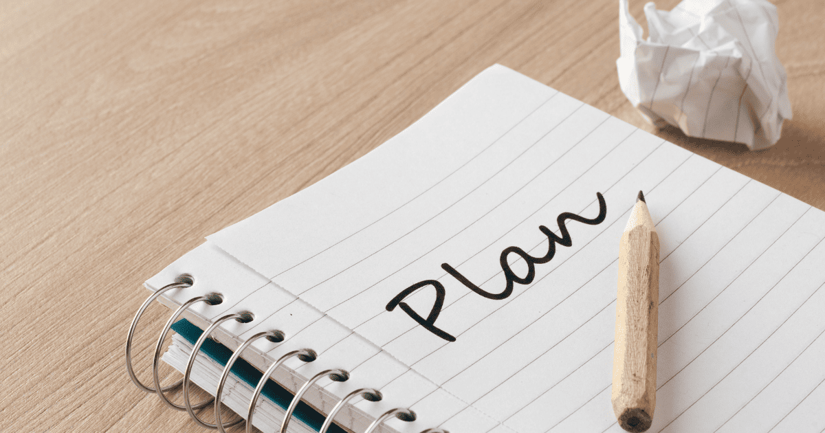 Cuaderno de notas con la palabra Plan escrita a lápiz para organizar la gestión de un negocio
