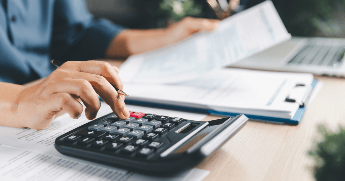 Autónoma revisando facturas y haciendo cálculos con una calculadora para la presentación de impuestos del 3T de 2026.